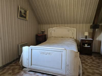 Chambre mansardée avec lit double laqué et tables de chevet anciennes