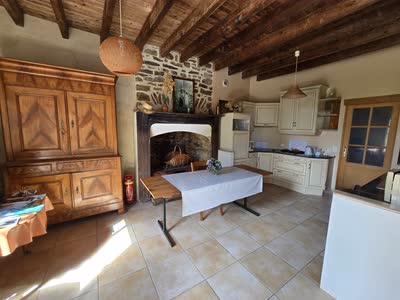 Le séjour du gîte, sa cheminée en pierre et son bahut ancien, ouvert sur la cuisine